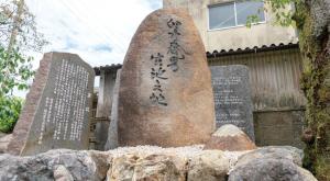 Large engraved memorial stones arranged among rocks and gravel.
