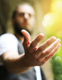 Blurred figure of a man reaching out his hand toward the viewer in a gesture of help or connection.