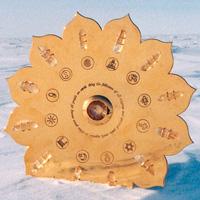 Golden, lotus-shaped energy grid with symbols arranged in a circle, displayed outdoors against a snowy landscape.