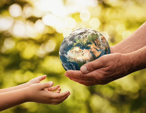 Older hands passing a globe to younger hands, symbolizing caring for the Earth and environmental responsibility.