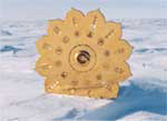 Golden peace grid standing on snowy ground, surrounded by ice and an open, frozen landscape located at the South Pole.